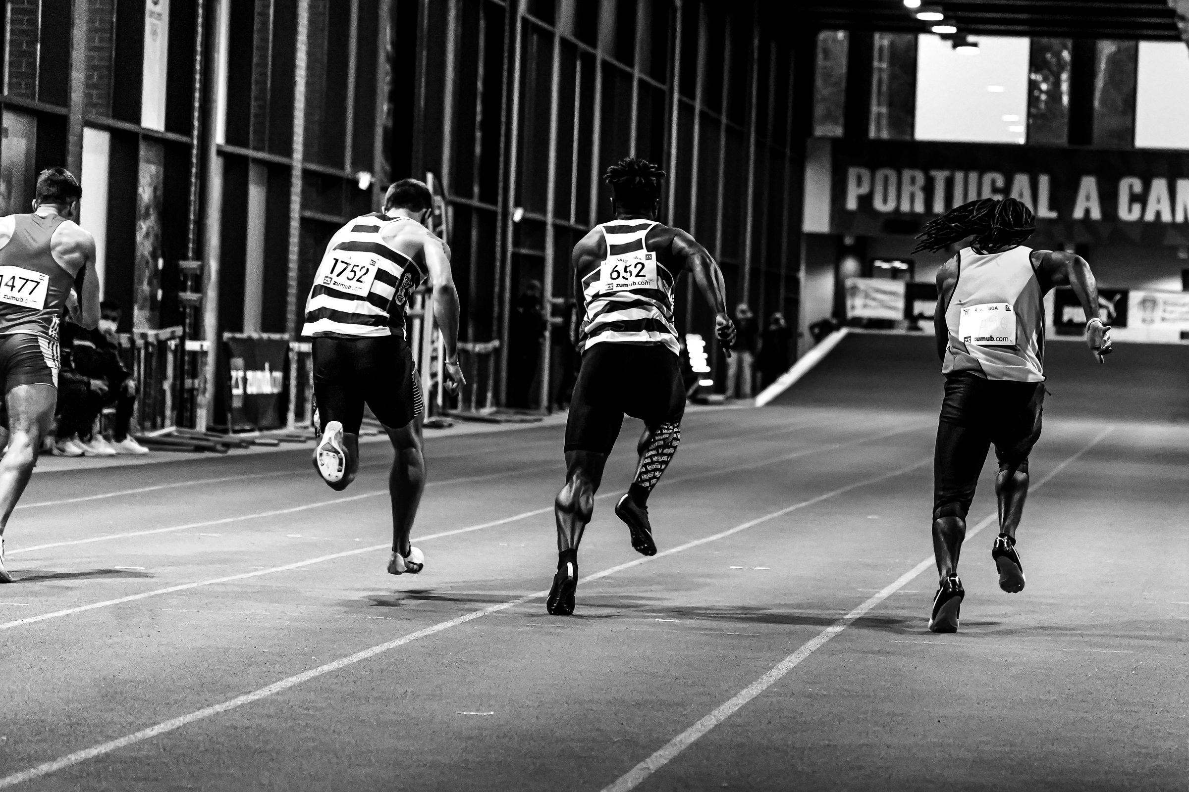 Sprinters at full flight on an indoor track